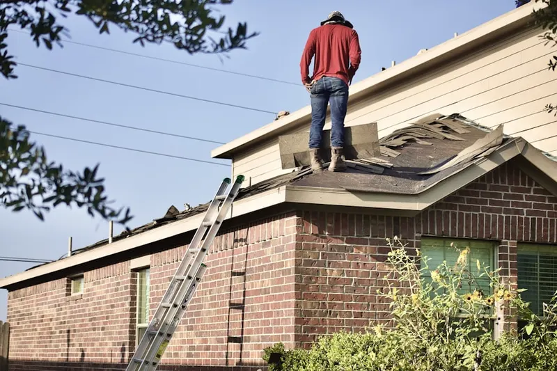Professional roofer working on a residential roof in Fort Payne